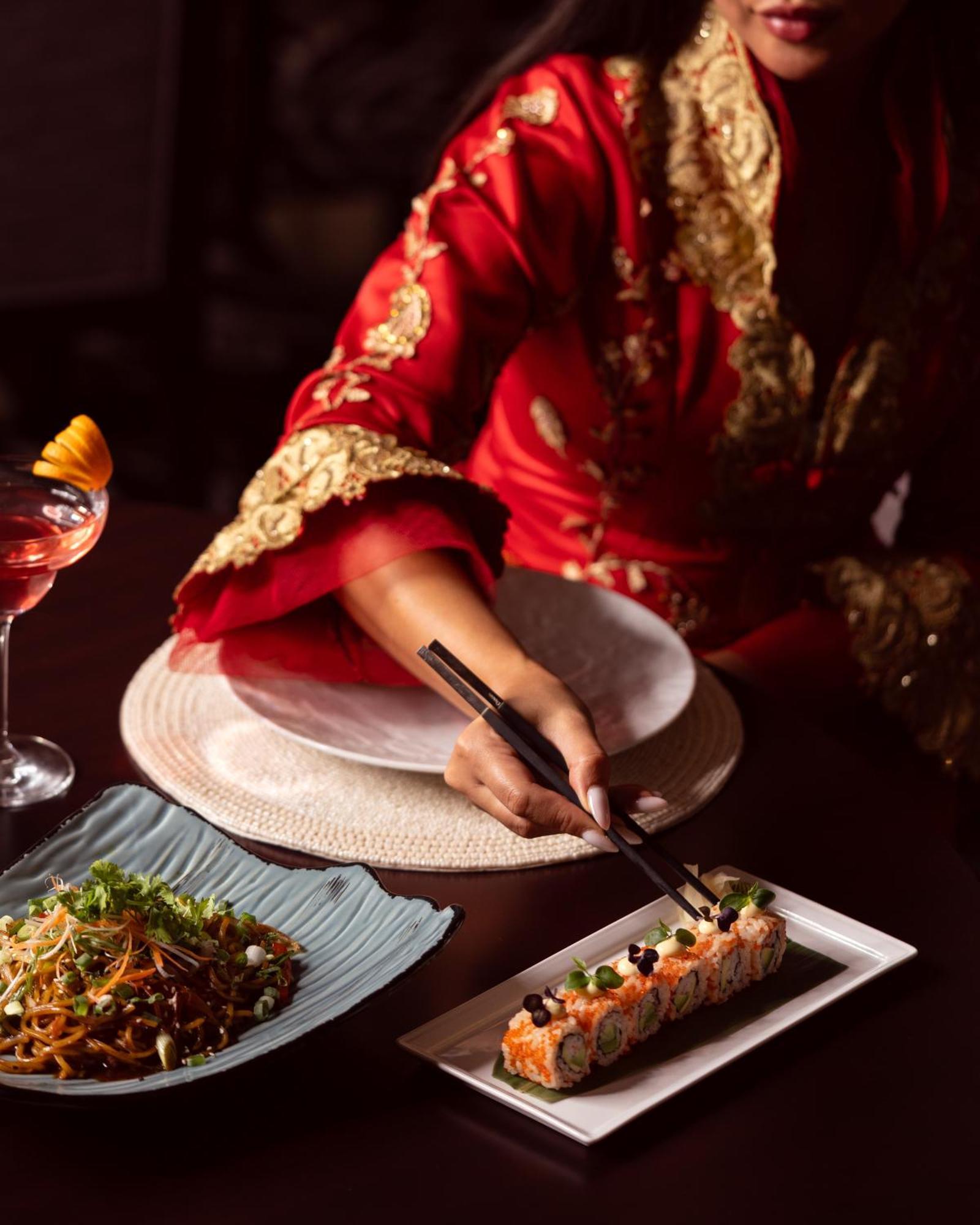 City Centre Rotana Dauhá Exteriér fotografie A woman using chopsticks